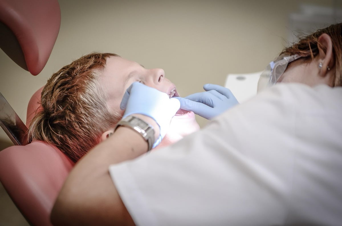 Dentist examining a patient to decide between a root canal and a tooth extraction
