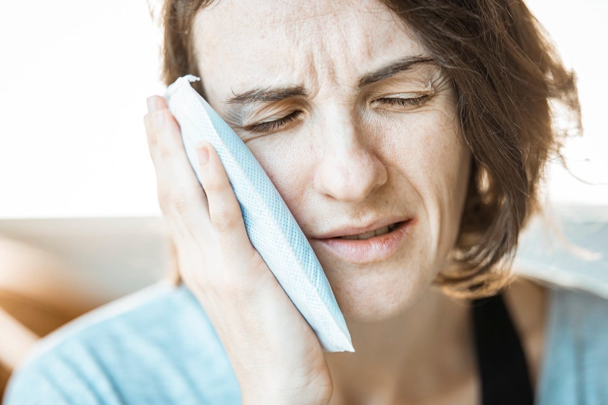 Tooth Pain With No Cavity Woman holding her cheek in pain from a toothache even though she has no cavity